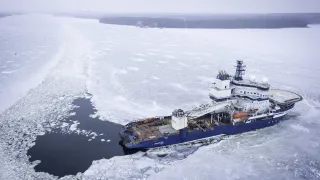 An aerial shot of an icebreaker ship going through ice in arctic conditions
