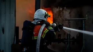 kuvituskuvassa pelastaja sammuttaa tulipaloa