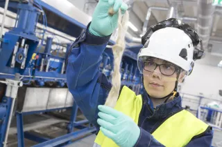 Photo of VTT researcher holding textile fibers.