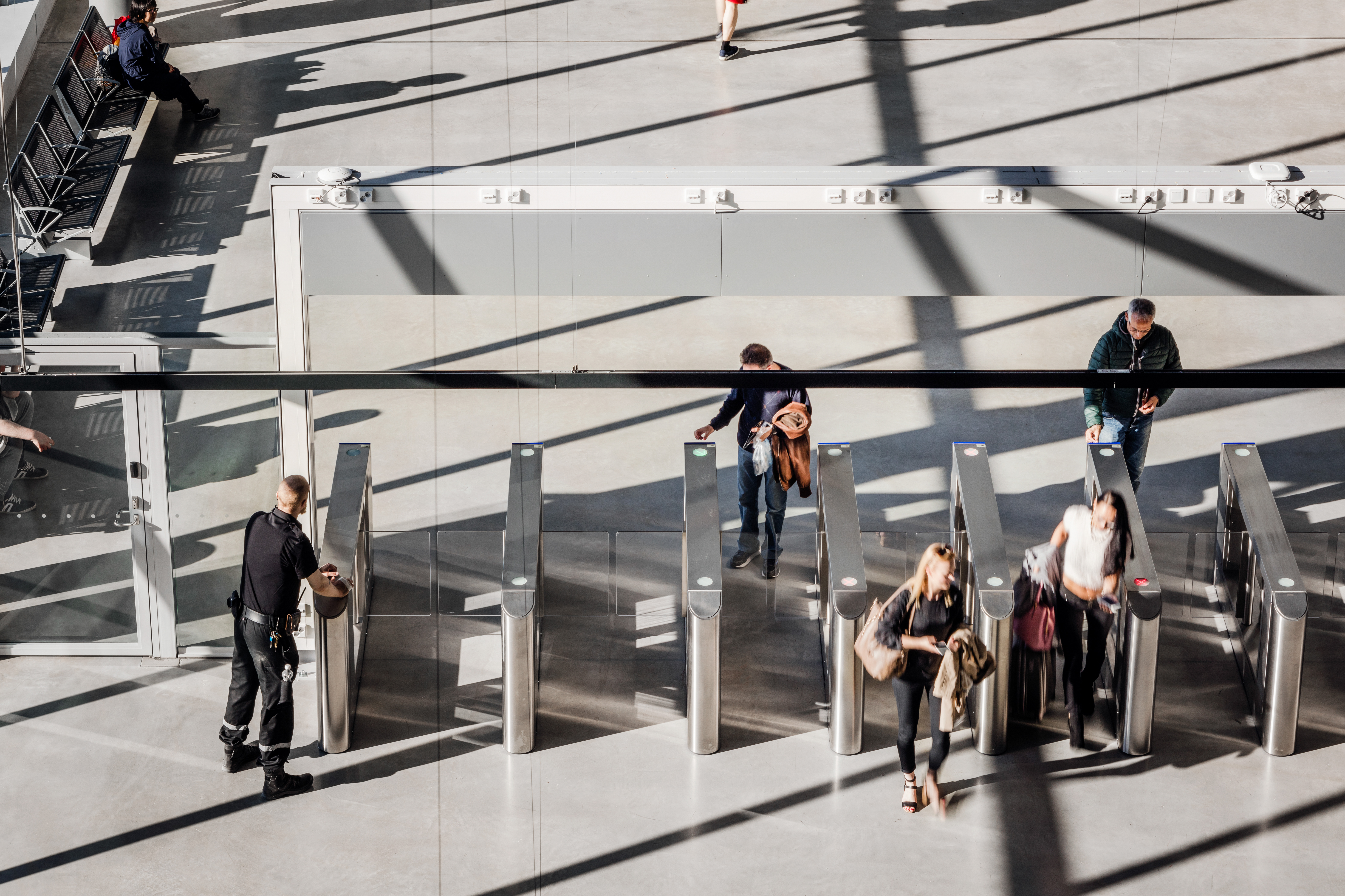 People are going though automatic gates checking their passports and tickets at the Länsisatama ferry terminal in Helsinki