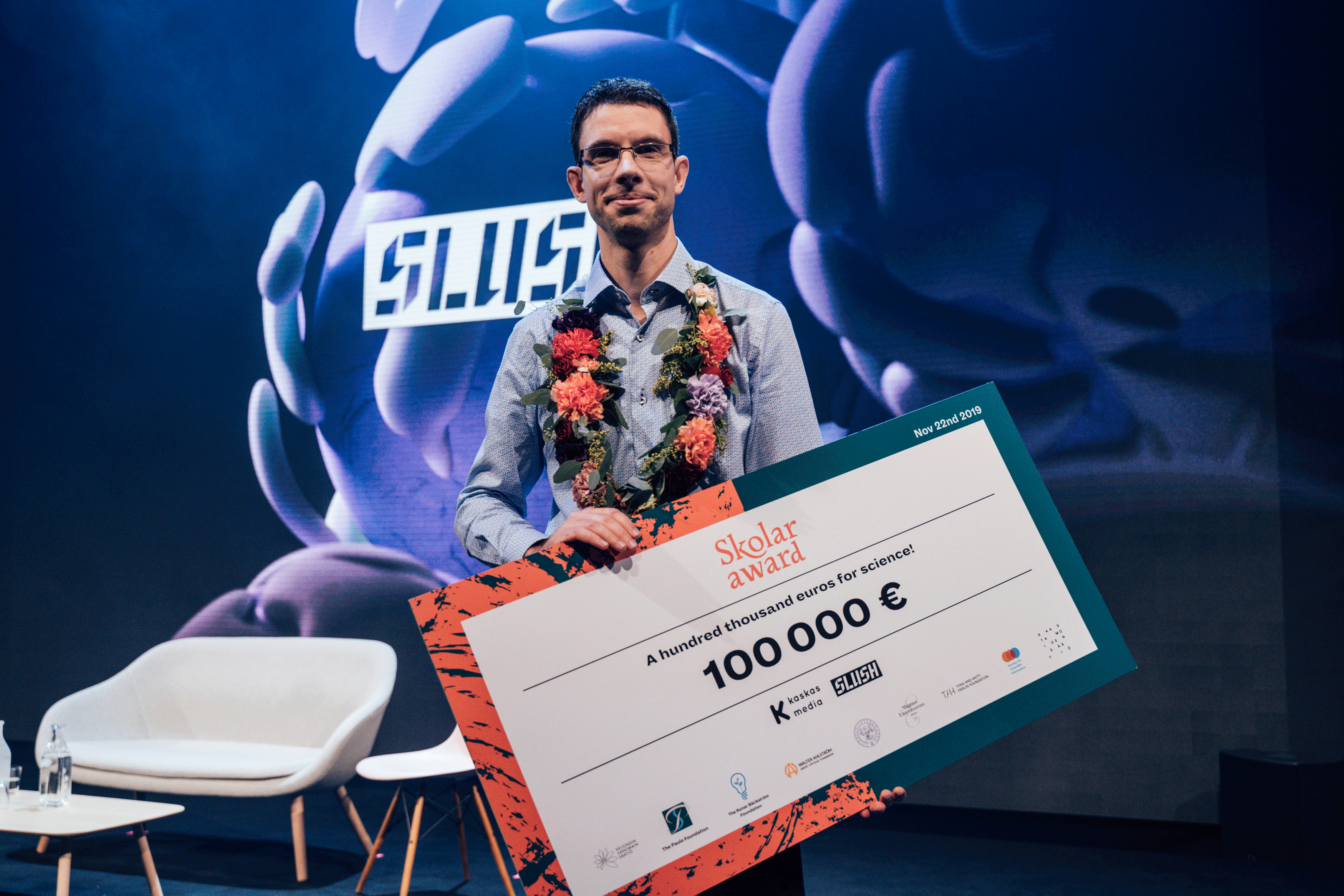 VTT&#039;s researcher Thomas Hausmaninger won the Skolar Pitching competition at Slush in 2019 and is posing with the winning 100,000 euro check.
