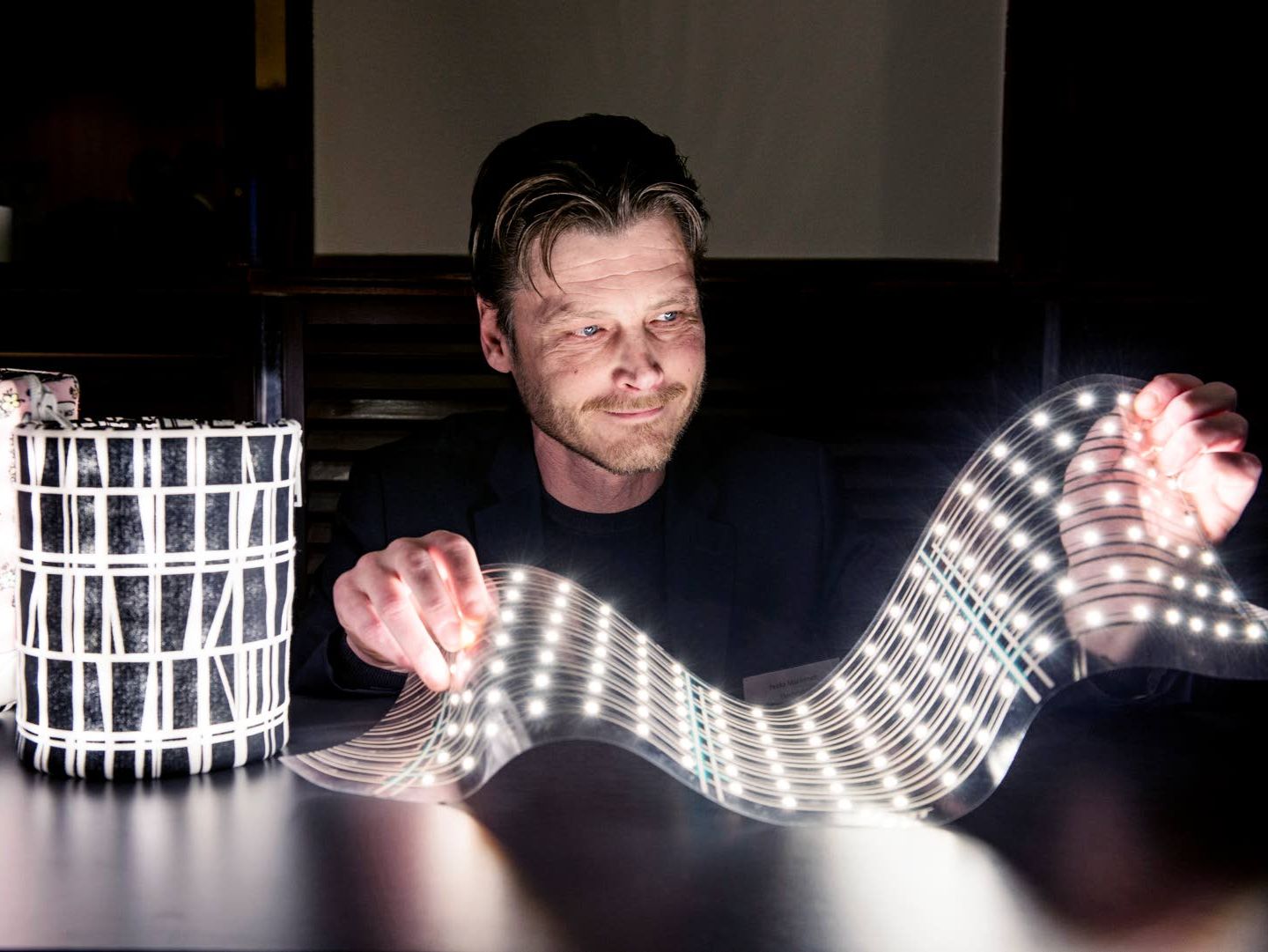 Flexbright's CEO Pekka Makkonen is holding an illuminated piece of flexible LED foil