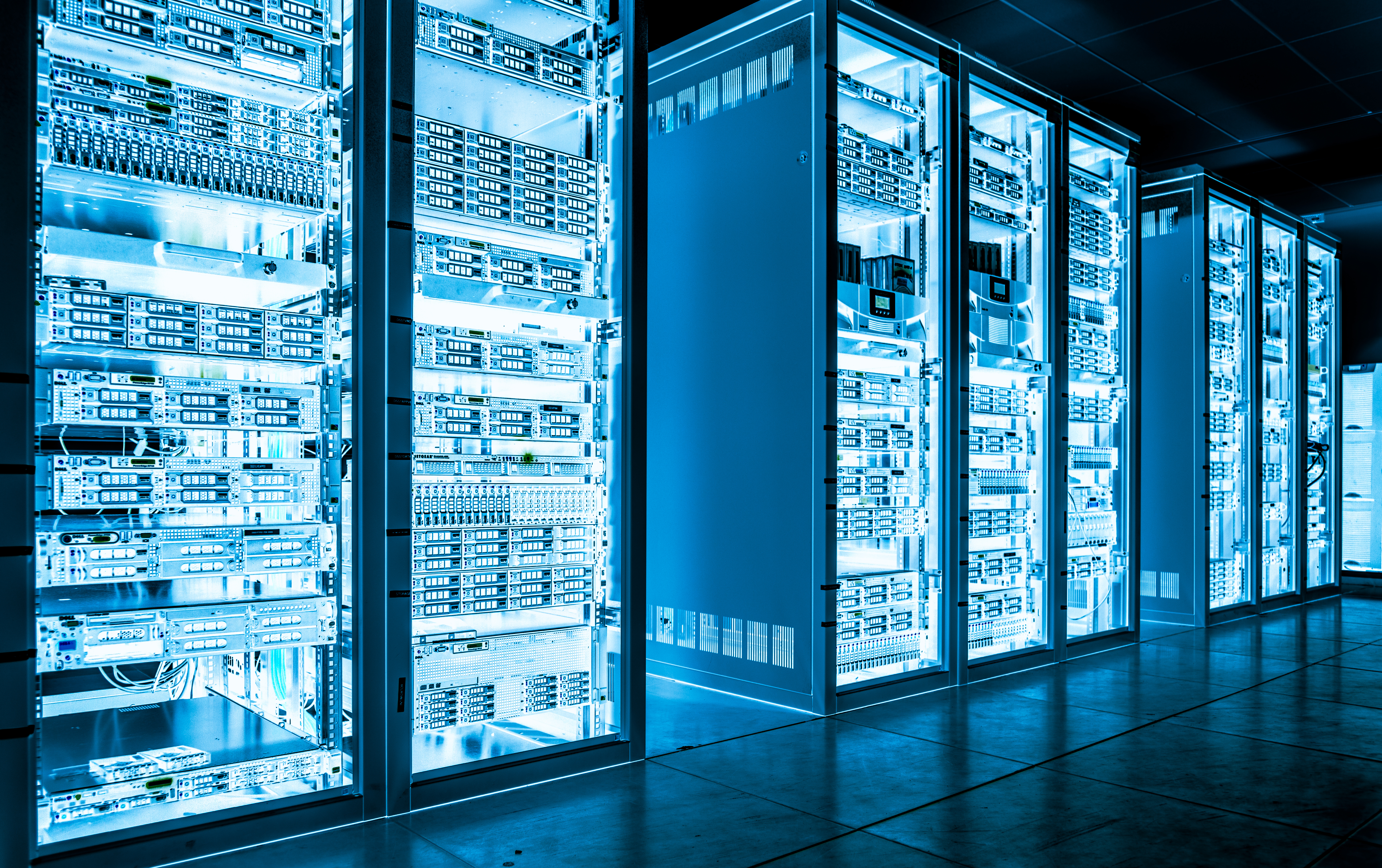 A photo of a dark server room with stacks of servers.
