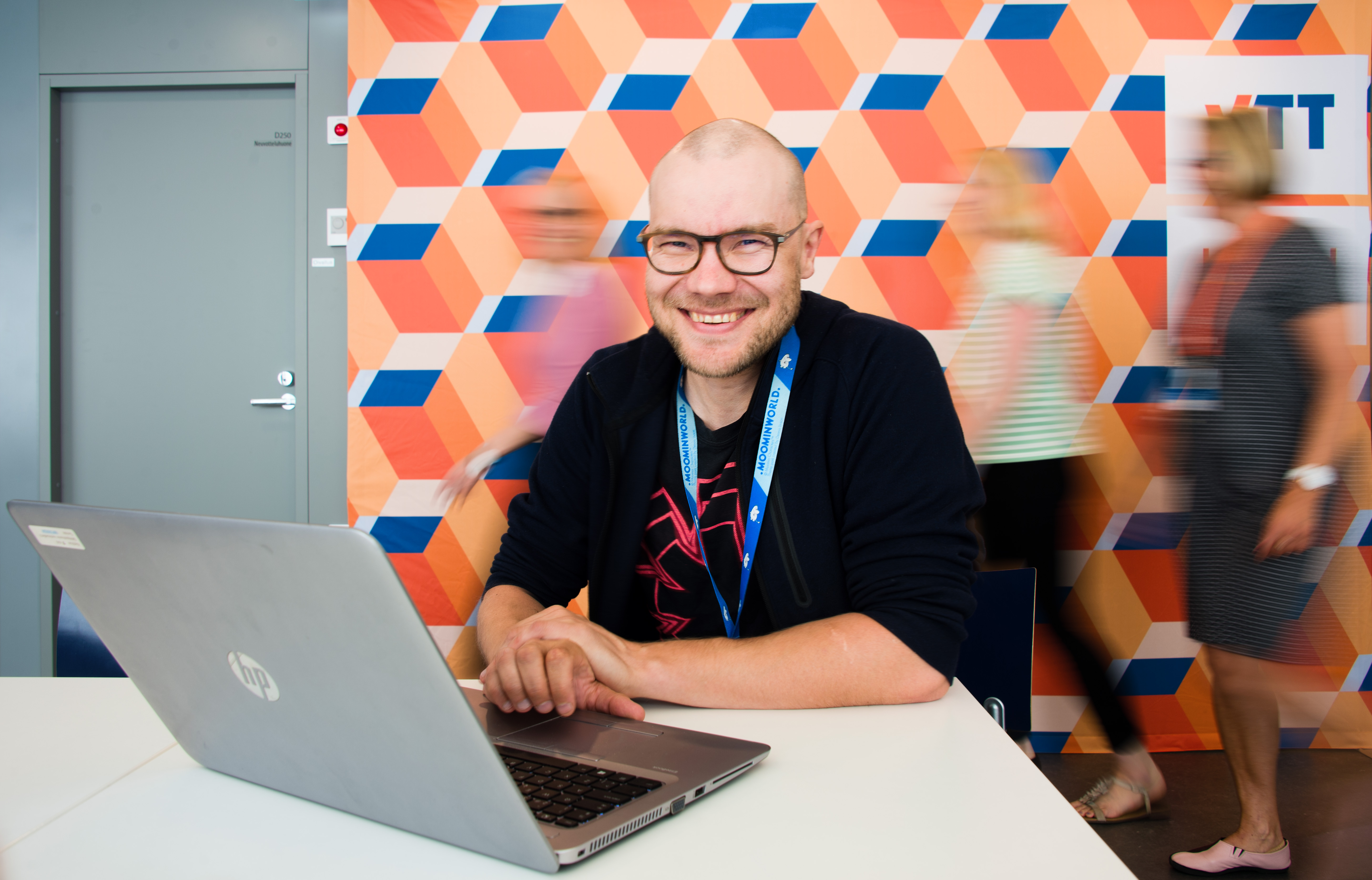 Senior Scientist Kari Antila from VTT's KnowledgeIntensive Products unit is sitting by a laptop and smiling.