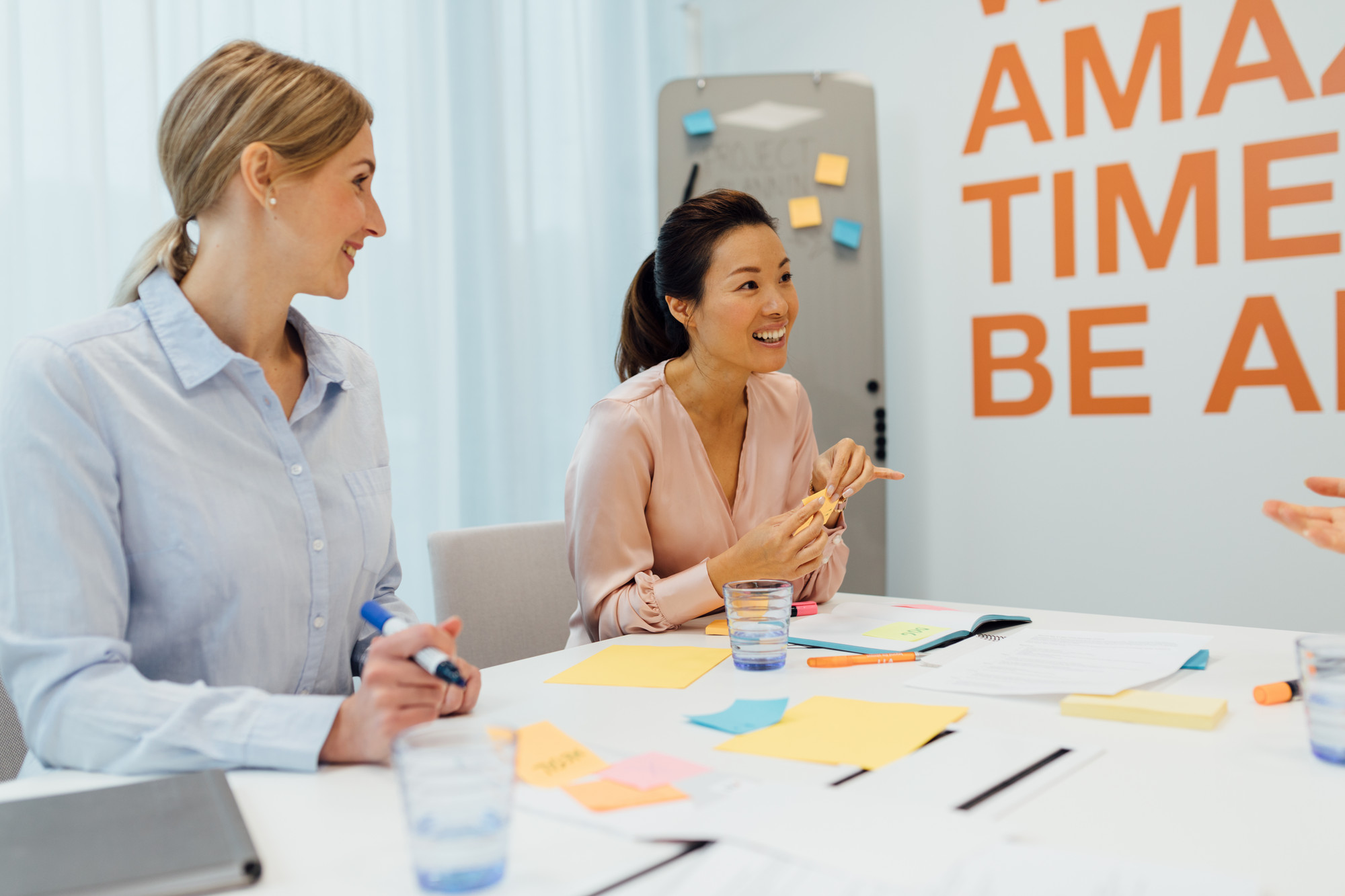 two women working together with postnotes
