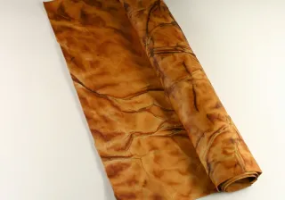 Roll of brown fungibased leather rolled out on table