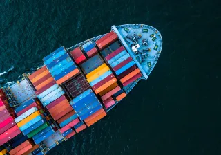 Photo of a freight ship carrying containers on the sea