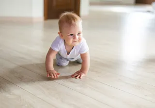 baby crawling on a wood floor