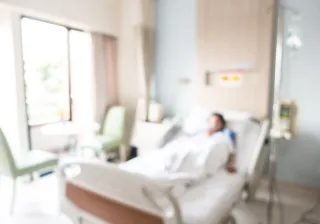 Blurry photo of a patient lying in a hospital bed