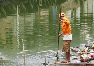 A man is cleaning debris out of a river