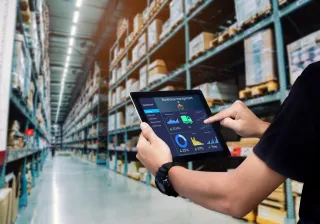 man managing a warehouse and holding a tablet
