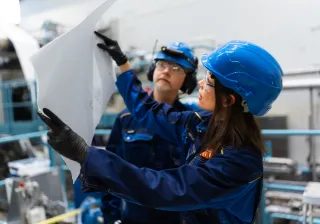 Researchers working in VTT&#039;s foam forming pilot examining sheet of material
