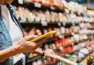 Woman using a phone in grocery store.