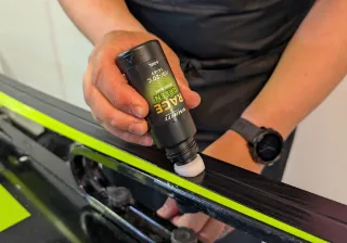 a person applying ski wax to a ski