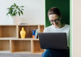 smilingwomanworkingonhercomputerinbooth