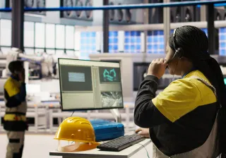personworkingwithacomputerinafactory