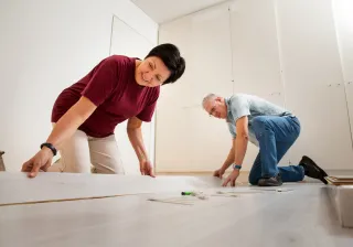 A couple renovating home by installing flooring