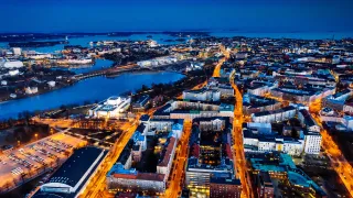 An aerial photo of Helsinki at night with the sea in the horizon