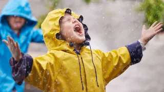 Lapsia leikkimässä sateessa.