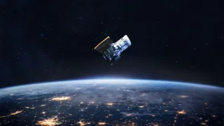A satellite orbiting in space with earth showing in the background.