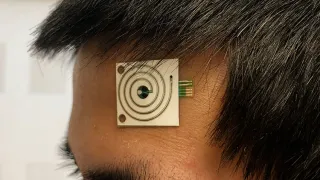 A squareshaped patch with electronic circuits attached to a person&#039;s forehead.