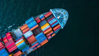 Photo of a freight ship carrying containers on the sea