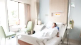 Blurry photo of a patient lying in a hospital bed