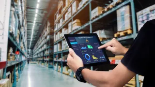 man managing a warehouse and holding a tablet