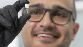 Pezhman Mohammadi presenting a dental implant crown made of VTT&#039;s nanocellulosebased composite