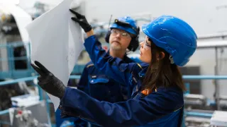 Researchers working in VTT&#039;s foam forming pilot examining sheet of material