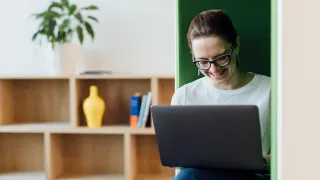 smilingwomanworkingonhercomputerinbooth