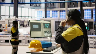 personworkingwithacomputerinafactory