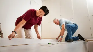 A couple renovating home by installing flooring