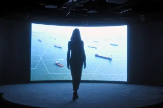 Silhouette of a woman walking towards a big screen