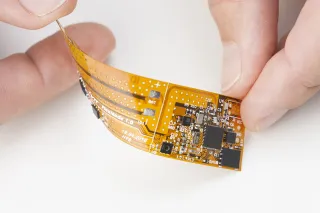 Hand holding flexible printed electronics sheet
