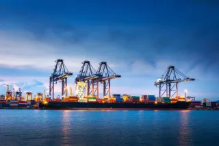 Maritime port landscape with cranes, ship and cargo