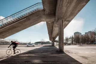 concrete bridge with cars and bikes going under