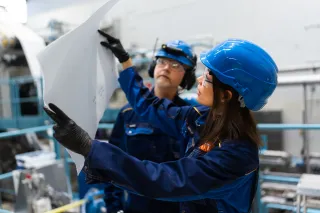 Researchers working in VTT&#039;s foam forming pilot examining sheet of material