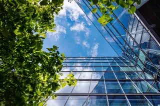blue sky view over a glass building with trees