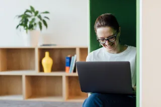 smilingwomanworkingonhercomputerinbooth