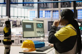 personworkingwithacomputerinafactory