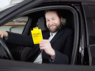 Man sitting in car holding package of test for testing alcohol levels