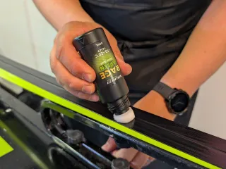 a person applying ski wax to a ski