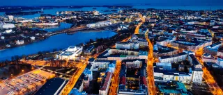 An aerial photo of Helsinki at night with the sea in the horizon