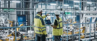 two manufacturing workers surveying a factory