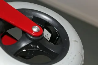 Valokuva älyrollaattorin pyörästä, jossa kiinni liikkumista mittaava anturi.